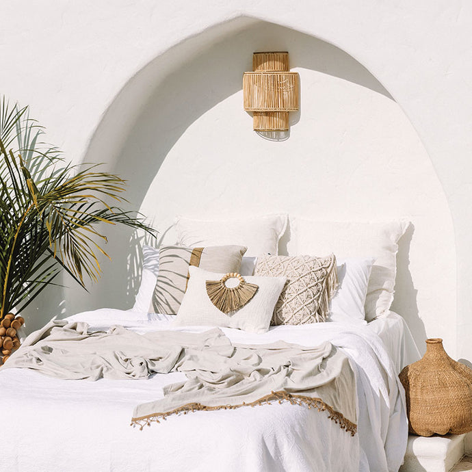 Cream boho cushion on beautiful boho styled bed. Cream cushion with seagrass cushion accessory.