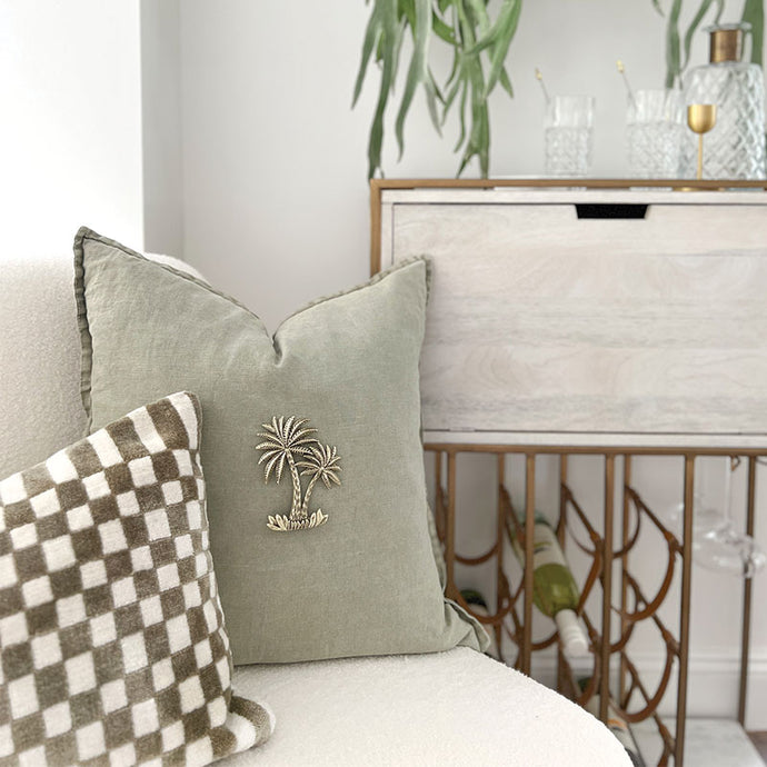 Sage tree tropical style cushion with brass palm cushion accessory. 50cm x 50cm cushion