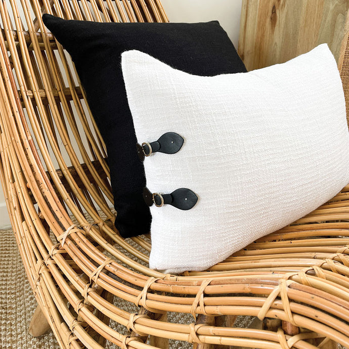 Modern cream cushion with black buckles.