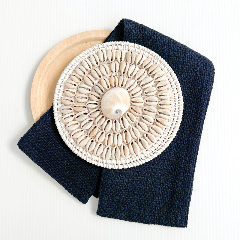 White coastal cushion with a rattan and shell disk, the perfect beach pillows for your coastal home. Shell rattan cushion accessory